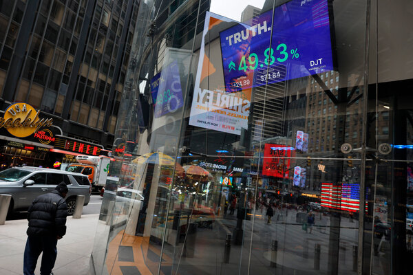 A blue TV screen inside a glass building shows the stock price for Trump Media and Technology Group.