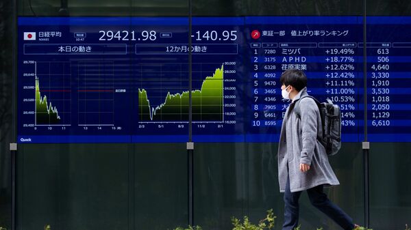 A man looks at screens showing Japan's Nikkei 225 index at a securities firm in Tokyo (AP / Hiro Komae)
