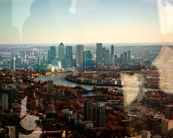 A view from high above the ground shows tall office buildings and trees along the Thames River.