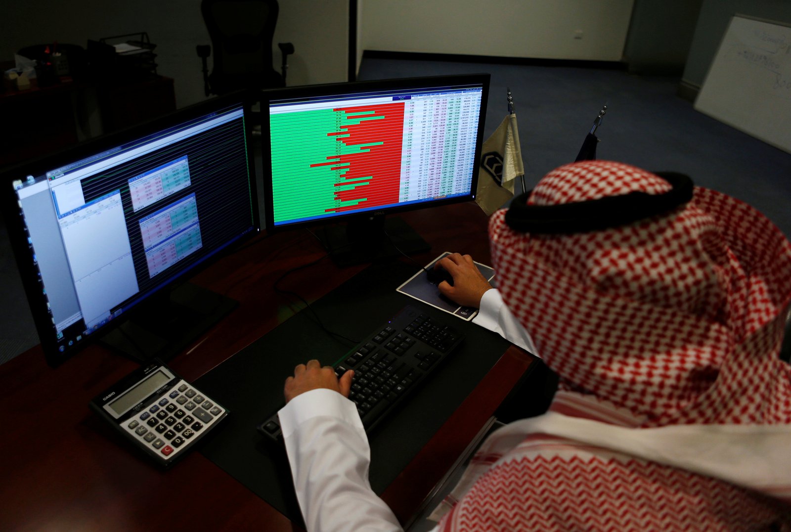 A Saudi trader observes the stock market on monitors at Falcom stock exchange agency in Riyadh