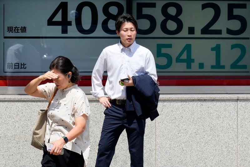 People stand in front of an electronic stock board showing Japan's Nikkei 225 index at a securities firm under the intense sun Monday, July 8, 2024, in Tokyo. (AP Photo/Eugene Hoshiko)