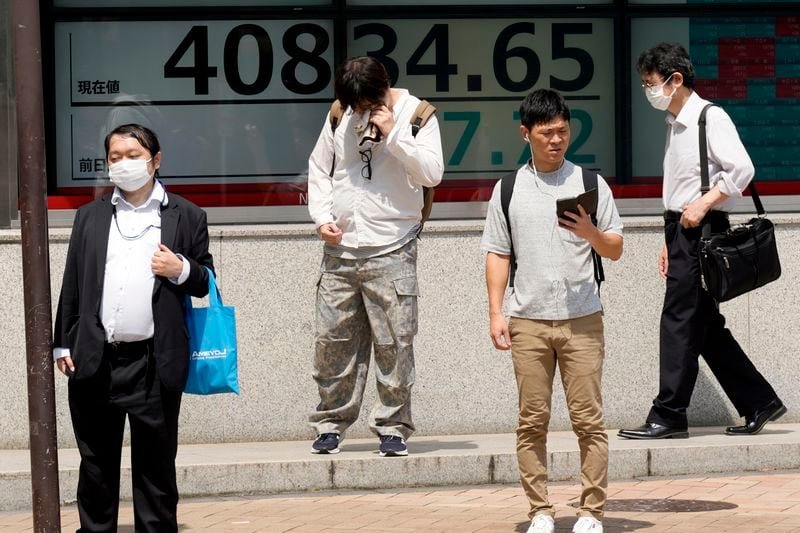 People stand in front of an electronic stock board showing Japan's Nikkei 225 index at a securities firm under the intense sun Monday, July 8, 2024, in Tokyo. (AP Photo/Eugene Hoshiko)