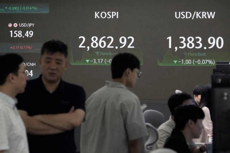 Currency traders work near the screen showing the Korea Composite Stock Price Index (KOSPI), top center, and the foreign exchange rate between U.S. dollar and South Korean won, top right, at the foreign exchange dealing room of the KEB Hana Bank headquarters in Seoul, South Korea, Wednesday, July 17, 2024. (AP Photo/Ahn Young-joon)