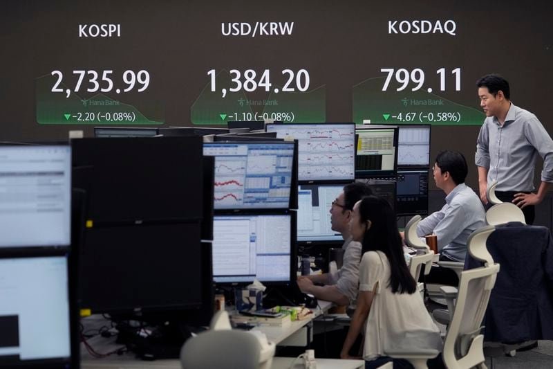 Currency traders watch monitors near the screen showing the Korea Composite Stock Price Index (KOSPI), top left, and the foreign exchange rate between U.S. dollar and South Korean won, top center, at the foreign exchange dealing room of the KEB Hana Bank headquarters in Seoul, South Korea, Wednesday, July 31, 2024. (AP Photo/Ahn Young-joon)