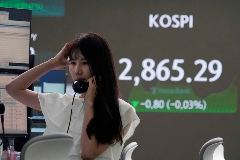 A currency trader talks on the phone near the screen showing the Korea Composite Stock Price Index (KOSPI) at the foreign exchange dealing room of the KEB Hana Bank headquarters in Seoul, South Korea, Wednesday, July 17, 2024. (AP Photo/Ahn Young-joon)