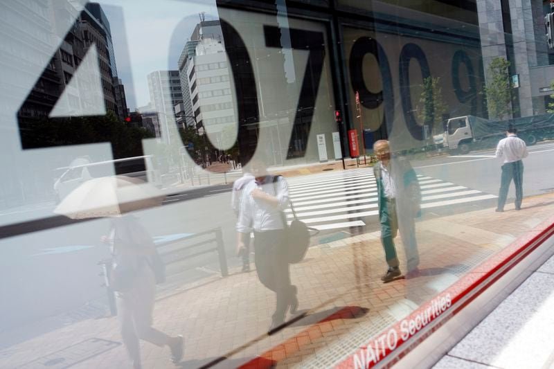 People are reflected on the window of an electronic stock board showing Japan's Nikkei 225 index at a securities firm Monday, July 8, 2024, in Tokyo. (AP Photo/Eugene Hoshiko)