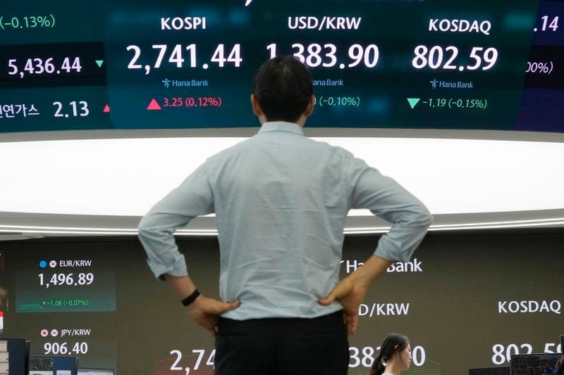 A currency trader watches the screen showing the Korea Composite Stock Price Index (KOSPI), top center left, and the foreign exchange rate between U.S. dollar and South Korean won, top center, at the foreign exchange dealing room of the KEB Hana Bank headquarters in Seoul, South Korea, Wednesday, July 31, 2024. (AP Photo/Ahn Young-joon)
