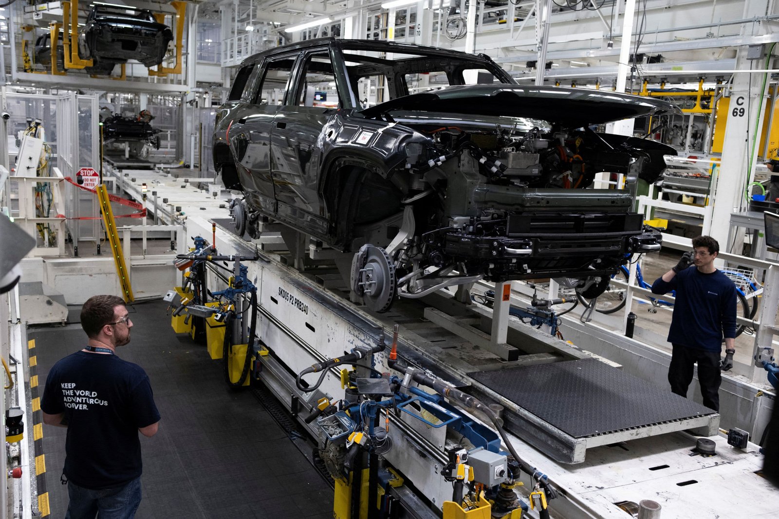 Workers assemble second-generation R1 vehicles at electric auto maker Rivian's manufacturing facility in Normal, Illinois, U.S. June 21, 2024. 