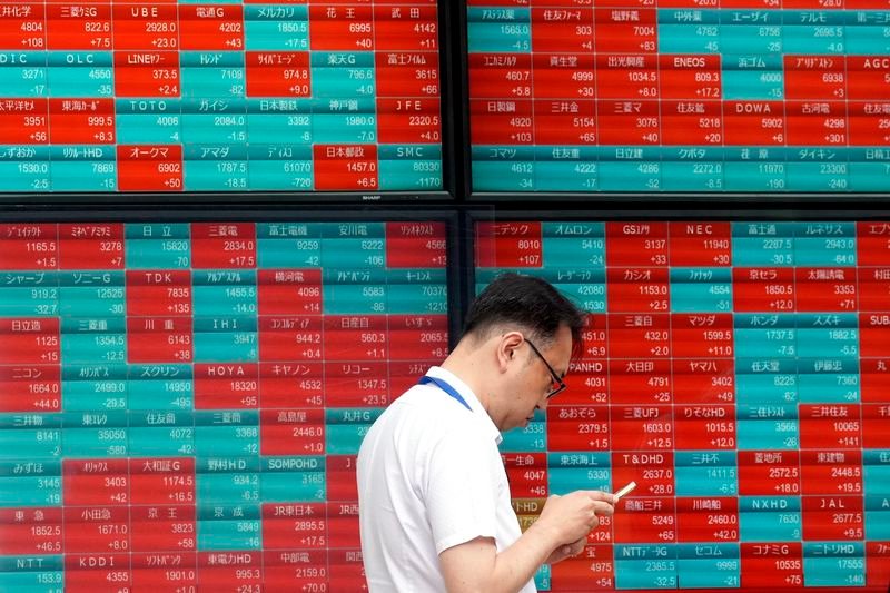 FILE - A person stands in front of an electronic stock board showing Japan's Nikkei index at a securities firm in Tokyo, on May 28, 2024. (AP Photo/Eugene Hoshiko, File)