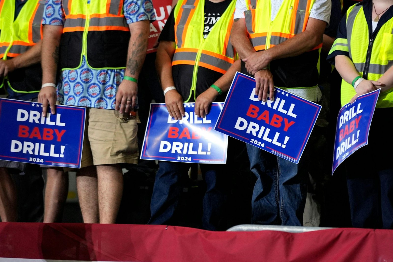 Trump supporters hold signs reading drill baby drill