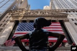 FILE - The New York Stock Exchange is shown behind the statue titled 