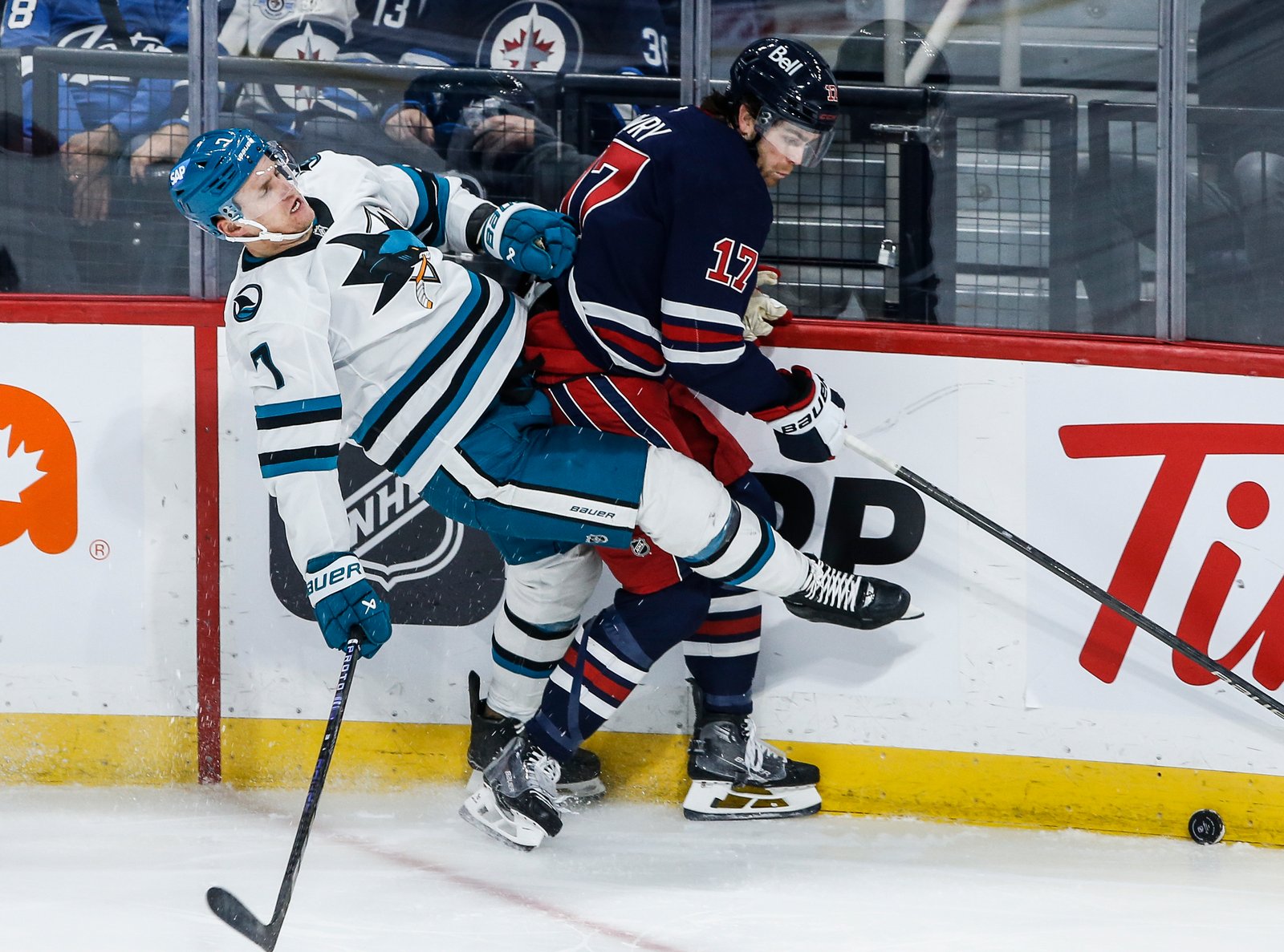 Winnipeg Jets' Adam Lowry (17) and San Jose Sharks' Nico Sturm (7) collide during third-period NHL hockey game action in Winnipeg, Manitoba, Friday, Oct. 18, 2024. (John Woods/The Canadian Press via AP)