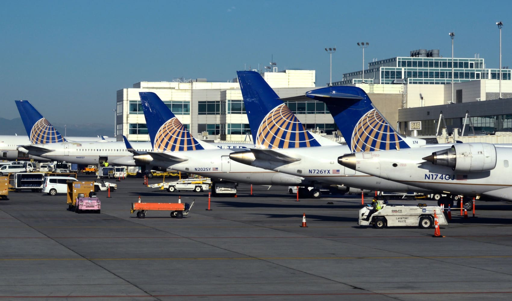 A row of United Airlines passenger planes parked at gates at Denver International Airport in Denver, Colorado.