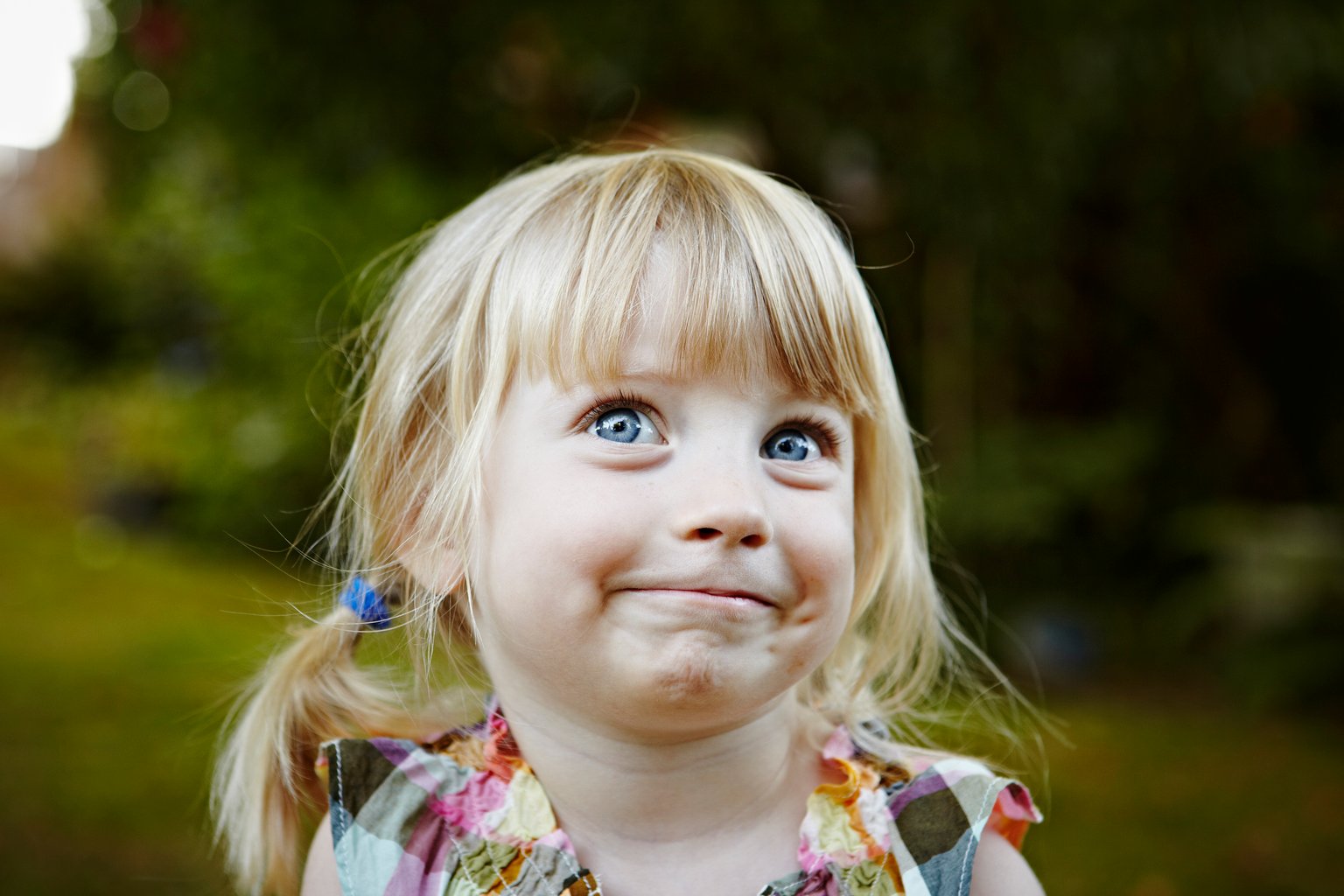 Young girl in backyard smiling looking up