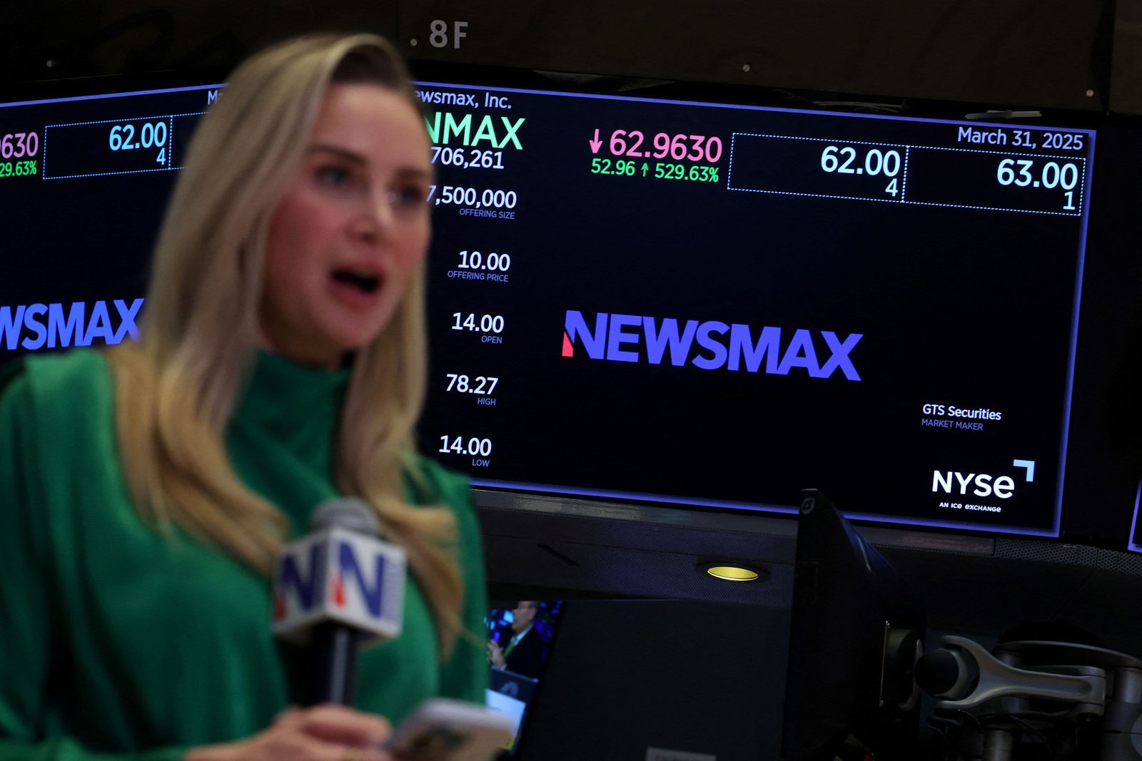 A Newsmax reporter works during the Newsmax Inc. IPO at the New York Stock Exchange in New York City, U.S., March 31, 2025.