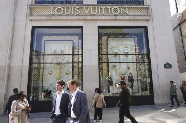 People walk by the Louis Vuitton flagship store Wednesday, April 9, 2025 in Paris. (AP Photo/Michel Euler)