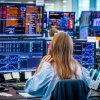 People look at computer screens showing stocks.