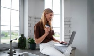 A Canadian woman banking on her laptop at home.