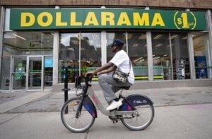 A person cycles past a Dollarama store in Montreal, Wednesday, June 7, 2023.