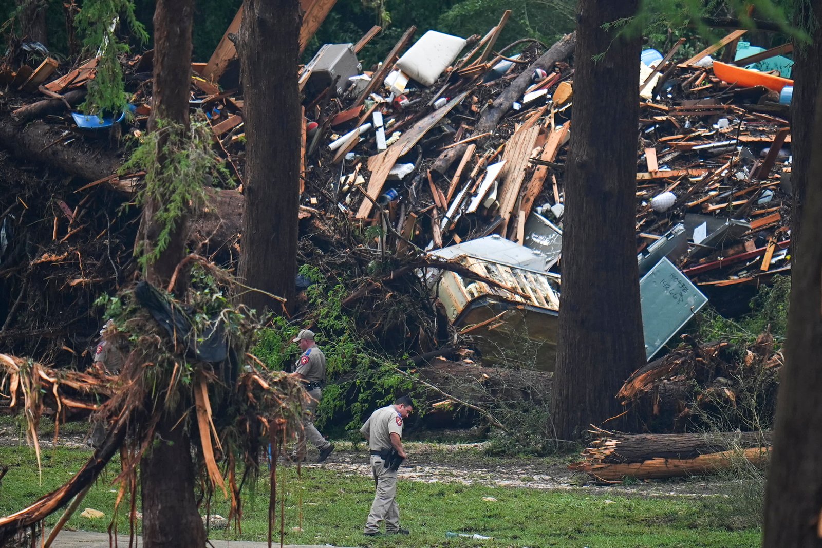 Officials comb through the banks of the Guadalupe River after a flash flood swept through the area on Saturday, July 5, 2025, in Hunt, Texas.