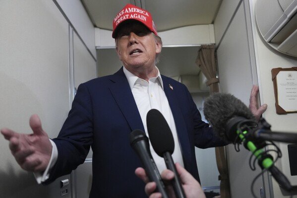 President Donald Trump speaks to reporters on board Air Force One, en route from Joint Base Andrews, Md., to Morristown Municipal Airport in Morristown, N.J., Friday, July 4, 2025. (AP Photo/Jacquelyn Martin)