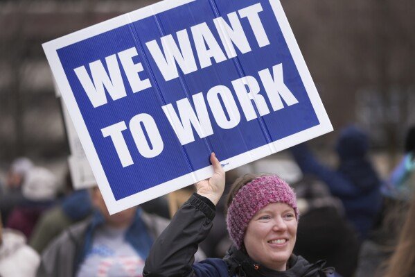 FILE - Katy Frank, a former computer scientist at the NOAA Great Lakes Environmental Research Lab, who lost her job Thursday, protests outside the John D. Dingell Veterans Affairs Medical Center in Detroit, Friday, Feb. 28, 2025. (AP Photo/Paul Sancya, File)