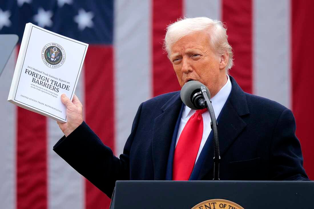 President Trump holds up a report outlining foreign trade barriers while announcing steep tariffs at the Rose Garden at the White House on April 2, 2025.