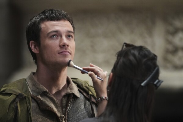 A makeup artist touches up the face of actor Jack Patten as Robin prior to an interview with The Associated Press about the Robin Hood ten-episode season in Belgrade, Serbia, Monday, May 5, 2025. (AP Photo/Darko Vojinovic)