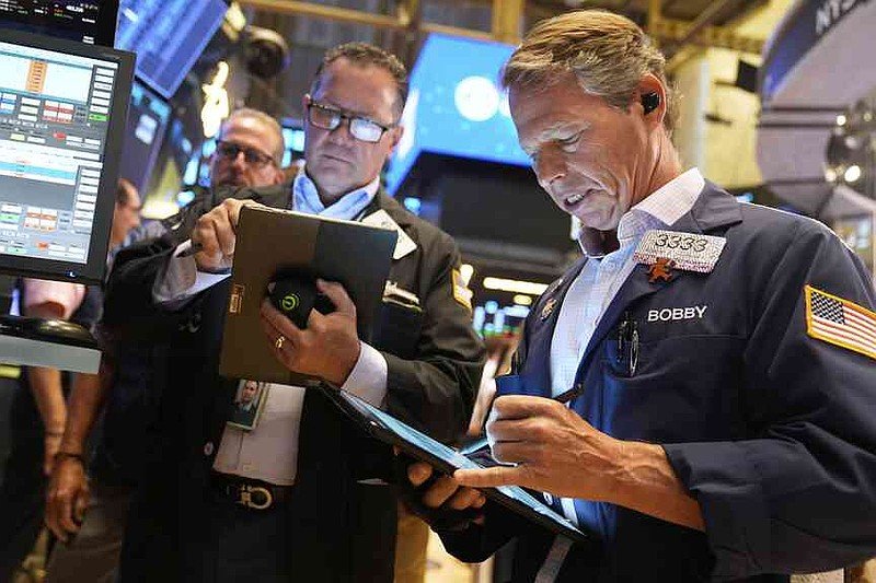 Robert Charmak, right, works on the floor at the New York Stock Exchange in New York, Wednesday, July 30, 2025. (AP Photo/Seth Wenig)