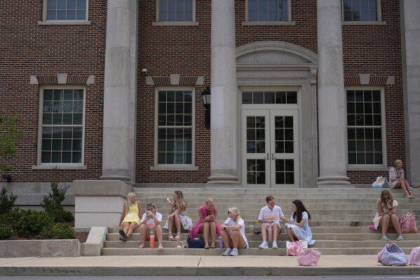 Sorority recruits line the sidewalk of sorority row at the University of Alabama, Thursday, Aug. 14, 2025, in Tuscaloosa, Ala. (AP Photo/Brynn Anderson)