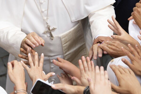 Pope Leo XIV greets faithful at the end of the Angelus prayer in Castel Gandolfo, Italy, Friday, Aug.15, 2025. (AP Photo/Gregorio Borgia)