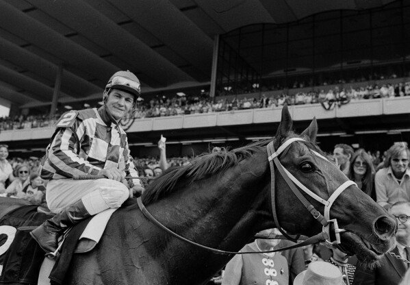 Jockey Ron Turcotte walks Secretariat towards the winners circle after they captured the Triple Crown by winning the Belmont Stakes at Belmont Park in Elmont, N.Y., June 9, 1973. (AP Photo, File)