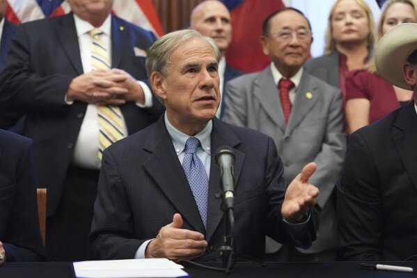 Texas Gov. Greg Abbott speaks to the media following a bill signing as Texas senators debate a bill on a redrawn U.S. congressional map during a special session in the Senate Chamber at the Texas Capitol in Austin, Texas, Friday, Aug. 22, 2025. (AP Photo/Eric Gay)