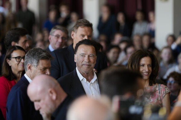 Former California Governor and actor Arnold Schwarzenegger, center, arrives for a ceremony to receive a honorary doctorate by the Hertie School, a university of governance, in Berlin, Germany, Sept. 17, 2024. (AP Photo/Markus Schreiber, File)