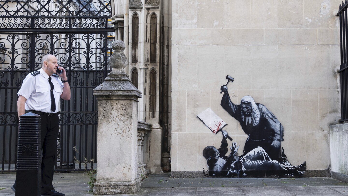 banksy-unveils-a-new-mural-of-a-judge-beating-a-protester-outside-london-court