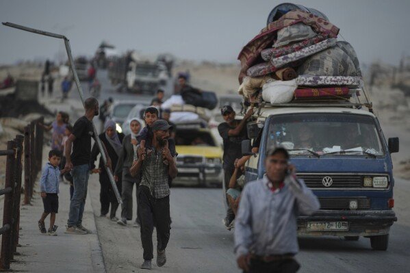Displaced Palestinians fleeing northern Gaza carry their belongings along the coastal road toward southern Gaza, Saturday, Sept. 6, 2025. (AP Photo/Jehad Alshrafi)