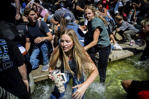 The crowd reacts after Charlie Kirk is shot during Turning Point's visit to Utah Valley University in Orem on Wednesday, Sept. 10, 2025. (Tess Crowley/The Deseret News via AP)