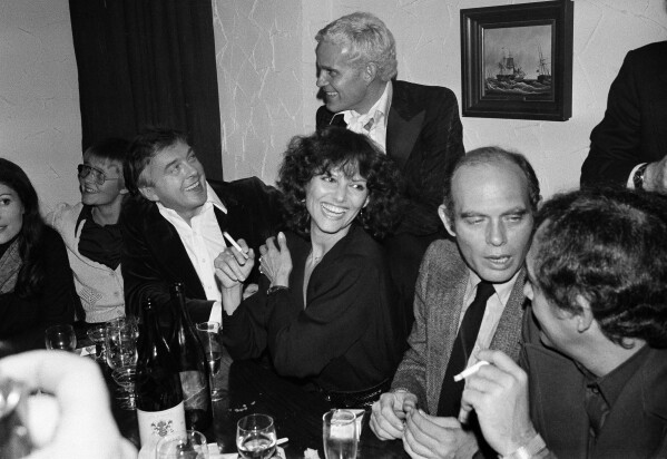 Italian actress Claudia Cardinale, center, chats with director David Hemmings, second from right, and actor Werner Pochath, during a reception for the 28th Berlin Film Festival at the Berlin studios, in Berlin, Feb. 26, 1978. (AP Photo/Edwin Reichert, File)