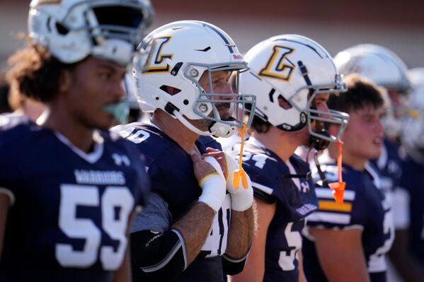 After seeing his first college football game action Lycoming College nose tackle Tom Cillo, second from left, stands on the sidelines during the second half of an NCAA Division III college football game against King' College in Williamsport, Pa., Sunday, Sept. 28, 2025. (AP Photo/Gene J. Puskar)