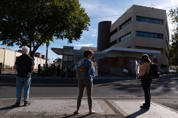 People protest outside a U.S. Immigration and Customs Enforcement facility on Sunday, Sept. 28, 2025, in Portland, Ore. (AP Photo/Jenny Kane)