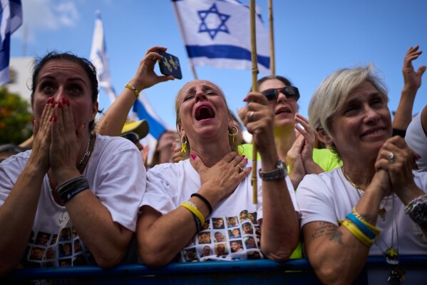 People react as they watch a live broadcast of Israeli hostages released from Hamas captivity in the Gaza Strip, at a plaza known as hostages square in Tel Aviv, Israel, Monday, Oct. 13, 2025. (AP Photo/Oded Balilty)