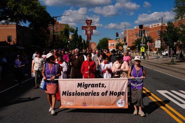 People walk from Shrine of the Sacred Heart to Cathedral of St. Matthew the Apostle during the first reflection procession in observance of the 111th world day of migrants and refugees and the jubilee of migrants, Sunday, Sept. 28, 2025, in Washington. (AP Photo/Julia Demaree Nikhinson)