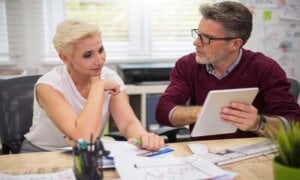 Man and woman sitting at a desk reviewing documents