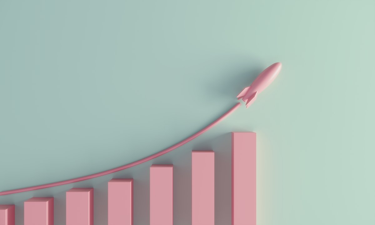 An ascending bar chart with a small rocket ship on top indicating growth.