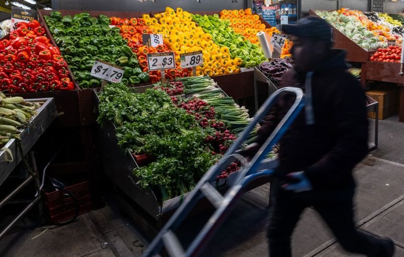 A man moves fruits and vegetables in a Brooklyn shopping district on Wednesday.