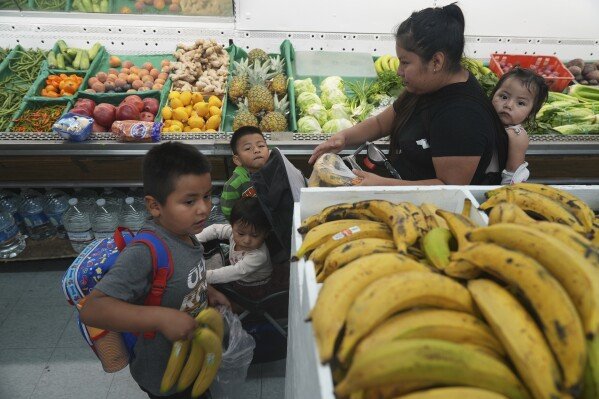 An immigrant mother originally from Guatemala purchases fresh fruits for her children with the balance left on her California EBT (Electronic Benefit Transfer) card used for SNAP benefits, in Los Angeles, Friday, Oct. 31, 2025. (AP Photo/Damian Dovarganes)