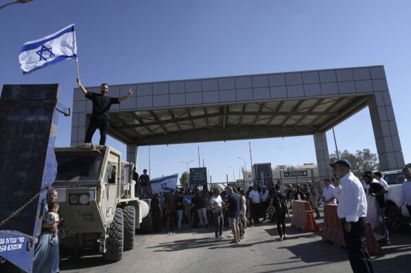 A protester waves the Israeli national flag in support of soldiers being questioned for detainee abuse outside of the Sde Teiman military base July 29, 2024. (AP Photo/Tsafrir Abayov)