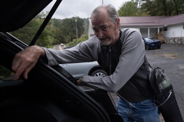 Former coal miner and black lung disease patient Roger James pauses with his supplemental oxygen to catch his breath after waking across the parking lot at the Maynor Freewill Baptist Church on Wednesday, Sept. 24, 2025, in Beckley, W.Va (AP Photo/Carolyn Kaster)