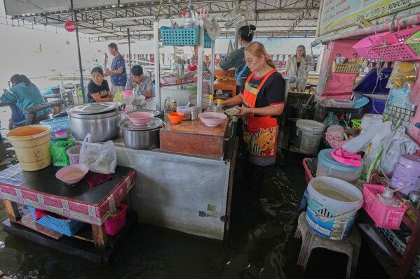 Pornkamol Prangprempree, front, making food for customer at the Pa Jit restaurant in Thailand's Nakhon Pathom Province west of Bangkok, Thailand, Friday, Nov. 14, 2025, (AP Photo/Sakchai Lalit)