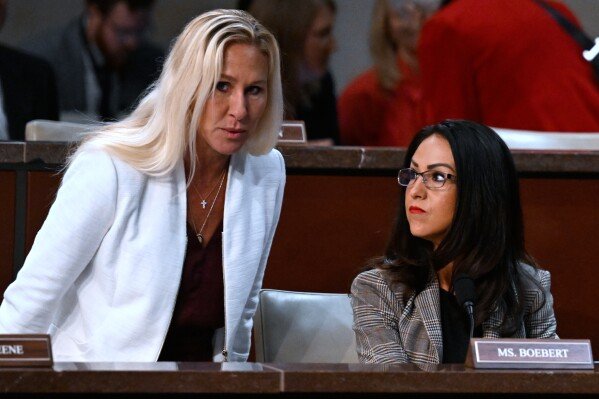 Rep. Marjorie Taylor-Greene, R-Ga., left, takes her seat next to Rep. Lauren Boebert, R-Colo., during the House Committee on Oversight and Government Reform as they begin marking up a slate of bills concerning the District of Columbia at the U.S. Capitol Sept.10, 2025, in Washington. (AP Photo/John McDonnell, File)